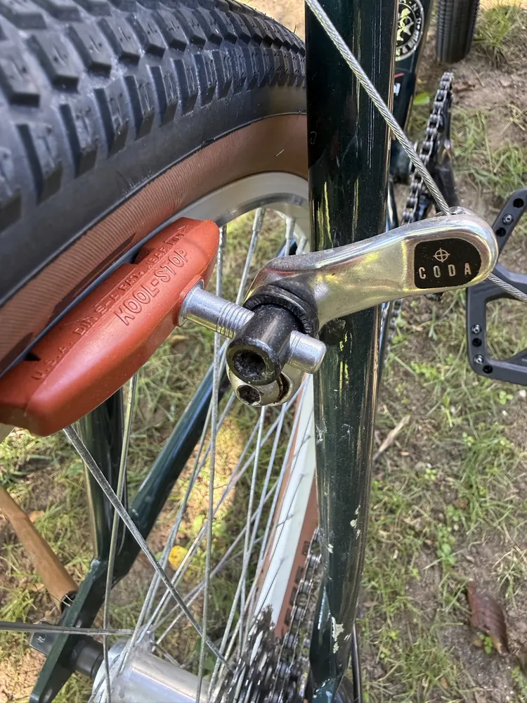 Polished CODA cantilever arm with a salmon Kool-Stop Thinline pad against the rim.